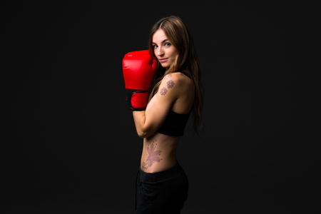 Sport woman with boxing gloves on dark backgroundの写真素材