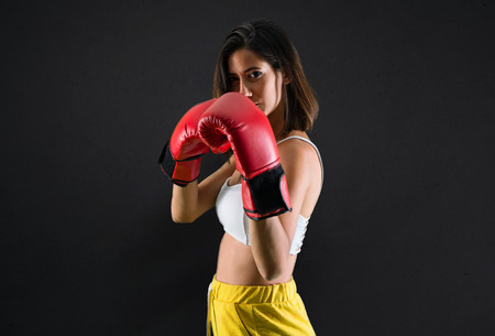 Sport woman with boxing gloves on black backgroundの写真素材