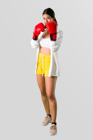Full body of Sport woman with boxing gloves on grey backgroundの写真素材