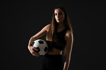 Young sport woman holding a soccer ballの写真素材