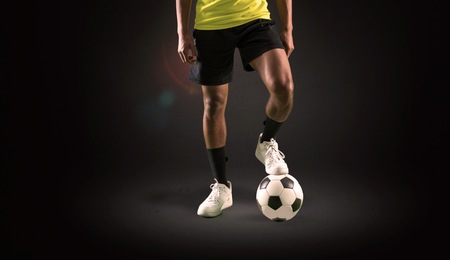 Soccer player man with dark skinned playing on dark backgroundの写真素材
