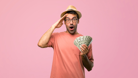 Man holding many bills has just realized something and has intending the solution on pink backgroundの写真素材