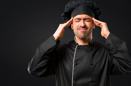 Chef man In black uniform unhappy and frustrated with something. Negative facial expression on black backgroundの写真素材