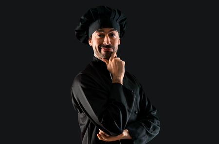 Chef man In black uniform on black backgroundの写真素材