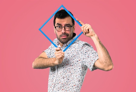 Handsome man with glasses holding a framework on pink backgroundの写真素材