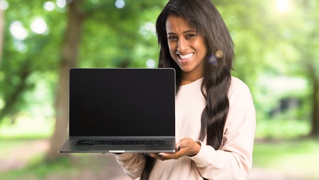 Young afro american woman showing a laptop at outdoorsの写真素材