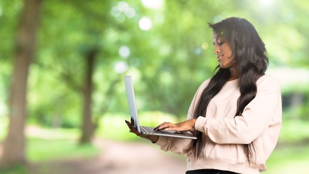 Young afro american woman with laptop at outdoorsの写真素材
