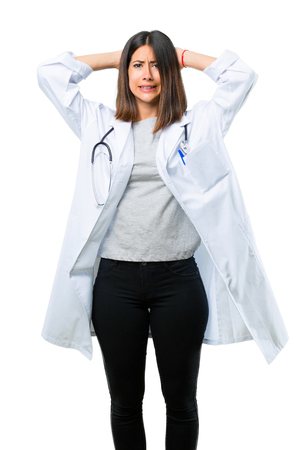 Doctor woman with stethoscope takes hands on head because has migraine on isolated white backgroundの写真素材