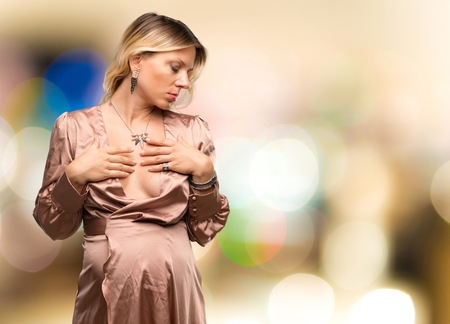 Pregnant blonde woman with elegant dress on unfocused backgroundの写真素材