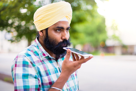 Indian with turban using mobile phone in outdoorsの写真素材