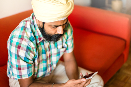 Indian with turban using mobile phoneの写真素材