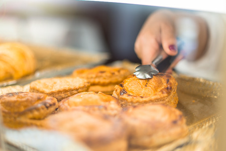 Person taking a salty piece of meat to sell it in a bakeryの写真素材
