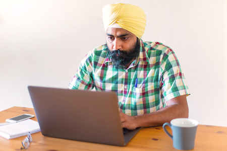 Indian with turban working with his laptopの写真素材