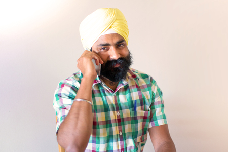 Indian with turban using mobile phoneの写真素材