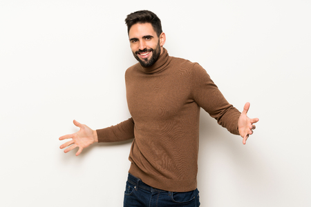 Handsome man over white wall proud and self-satisfied in love yourself conceptの写真素材