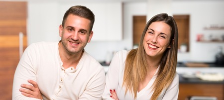Couple keeping the arms crossed while smiling in a houseの写真素材