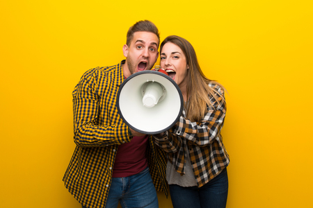 Couple in valentine day shouting through a megaphoneの写真素材