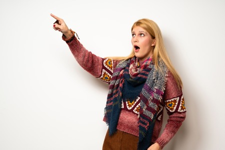 Hippie woman over white wall pointing awayの写真素材