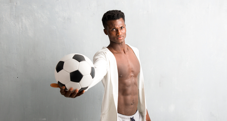 African american sportman holding a soccer ballの写真素材