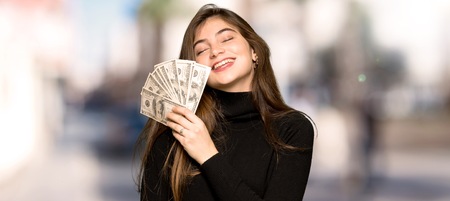 Pretty girl taking a lot of money at outdoorsの写真素材