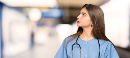 Young nurse looking up with serious face in a hospitalの写真素材
