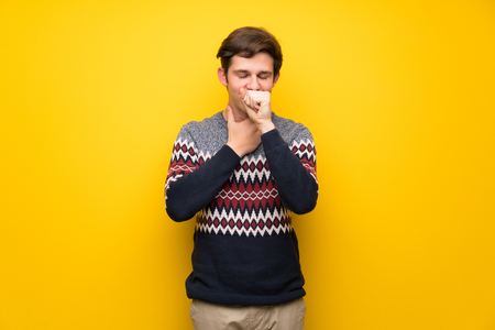 Teenager man over yellow wall is suffering with cough and feeling badの写真素材