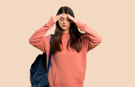Teenager girl with sweatshirt and backpack unhappy and frustrated with something on color backgroundの写真素材