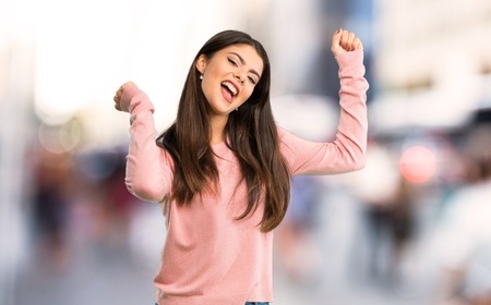 Teenager girl with pink shirt enjoy dancing while listening to music at a party at cityの写真素材