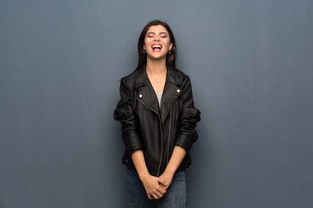 Teenager girl over grey wall shouting to the front with mouth wide openの写真素材