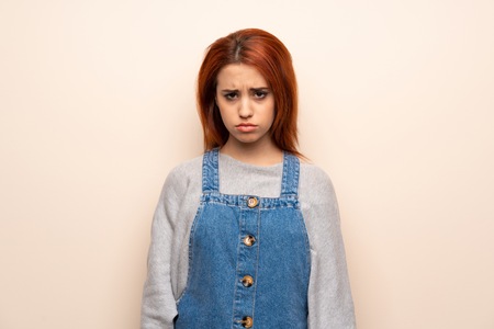 Young redhead woman over isolated background with sad and depressed expressionの写真素材