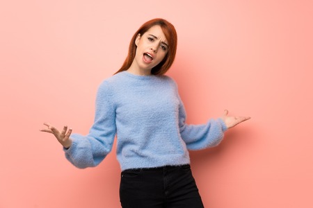 Young redhead woman over pink background proud and self-satisfied in love yourself conceptの写真素材