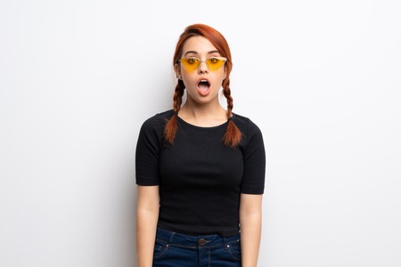 Young redhead woman over white wall with surprise facial expressionの写真素材