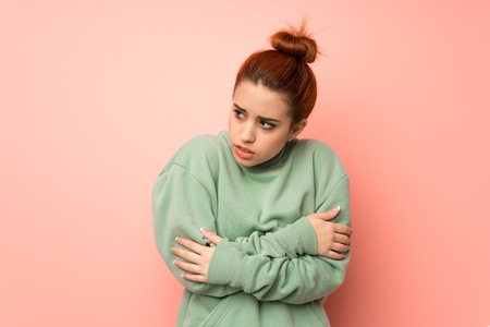 Young redhead woman with sweatshirt freezingの写真素材