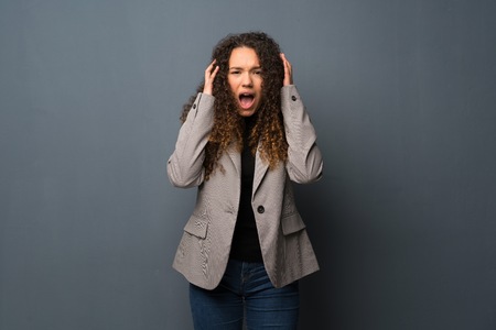 Teenager girl over blue wall nervous and scared stretching hands to the frontの写真素材