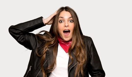 Young woman with leather jacket with surprise and shocked facial expression over isolated grey backgroundの写真素材