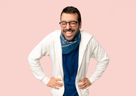 Handsome man with glasses happy and smiling on isolated pink background