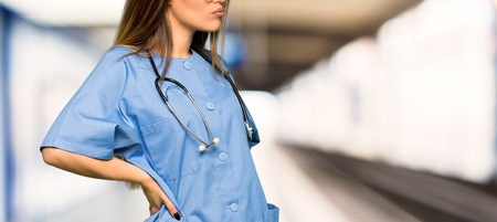 Young nurse suffering from backache for having made an effort in a hospital