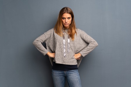 Blonde woman over grey background angry