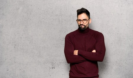 Handsome man with glasses feeling upset over textured wallの写真素材