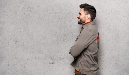Handsome man with beard in lateral position over textured wallの写真素材