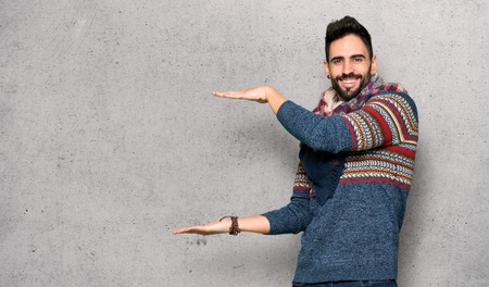 Hippie man holding copyspace to insert an ad over textured wallの写真素材