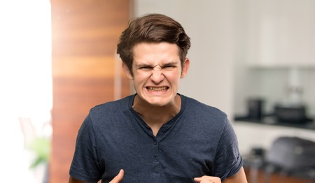 Teenager man frustrated by a bad situation at indoorsの写真素材
