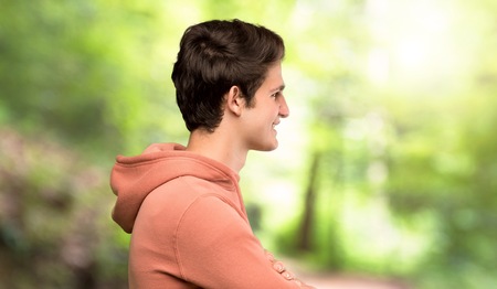 Teenager man with sweatshirt in lateral position at outdoorsの写真素材