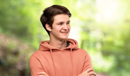 Teenager man with sweatshirt Happy and smiling at outdoorsの写真素材