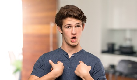 Teenager man with surprise facial expression at indoorsの写真素材