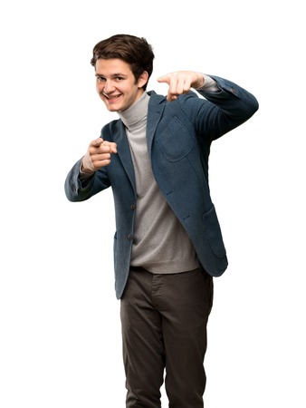 Teenager man with turtleneck points finger at you while smiling over isolated white backgroundの写真素材