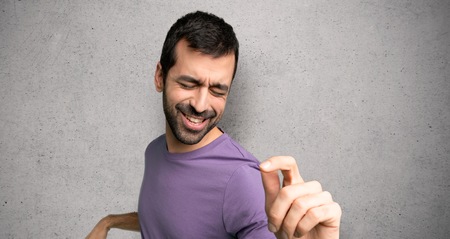 Handsome man enjoy dancing while listening to music at a party over textured wallの写真素材
