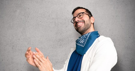 Handsome man with glasses applauding after presentation in a conference over textured wallの写真素材
