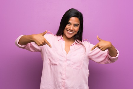 Young Colombian girl over purple wall proud and self-satisfiedの写真素材