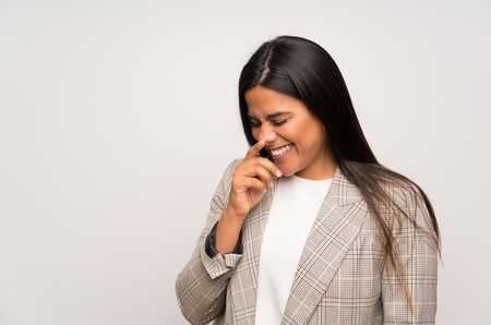 Young Colombian girl over white wall laughing